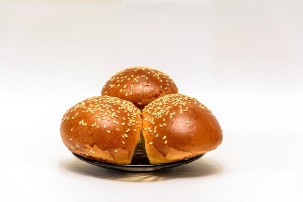 Buns sprinkled with sesame seeds bakery products three buns
isolated on a white backcground