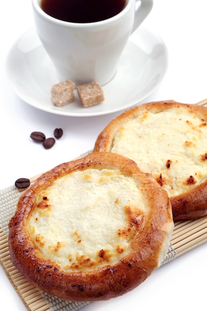 Buns with cottage cheese and coffee cup on white background