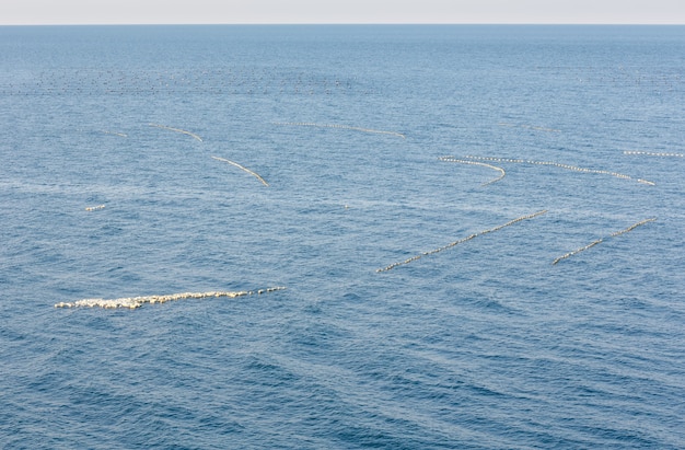 Photo buoys of dragnet on blue sea water surface.