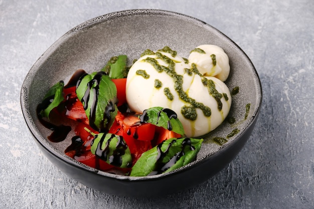 Buratta. insalata con buratta, pesto, basilico, pomodori e balsamico. insalata caprese con buratta.