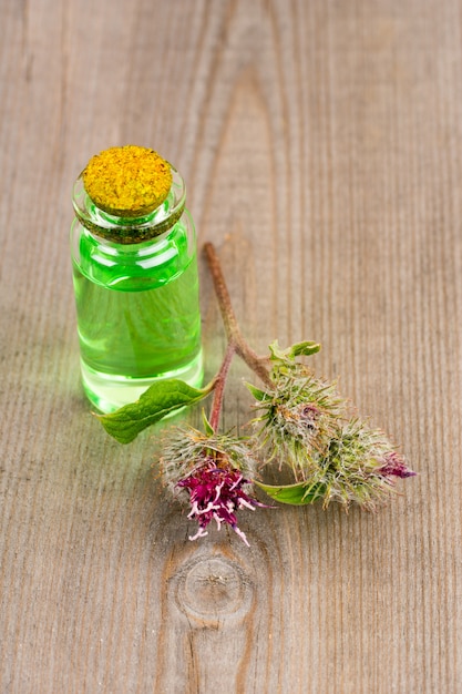 Burdock essential oil for spa or massage, vertical image