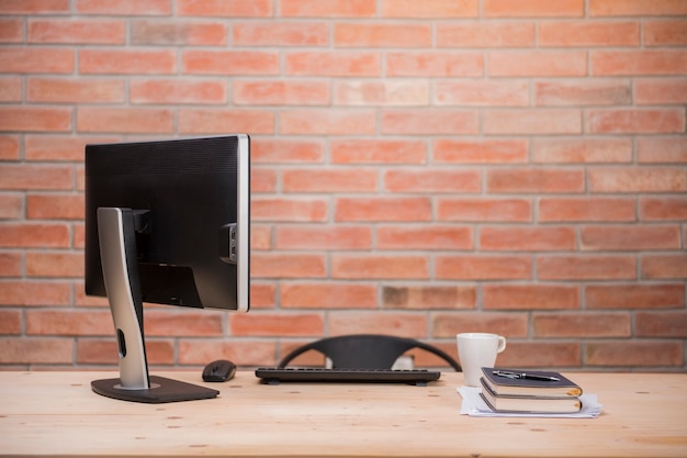 Bureau met computer, boeken en mok