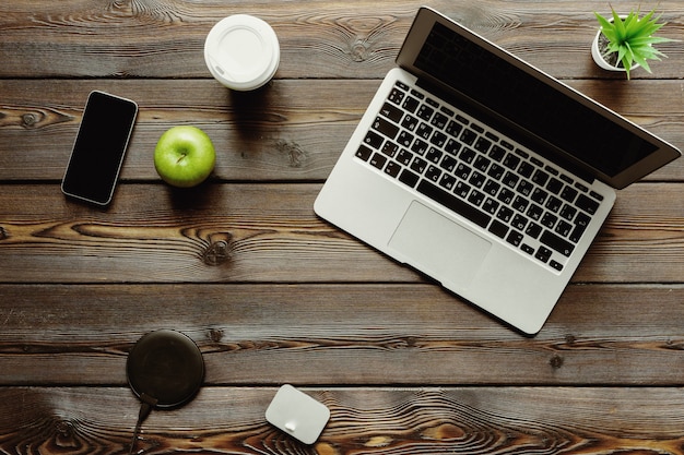 Bureau met laptopcomputer, leveringen en groene appel, bovenaanzicht