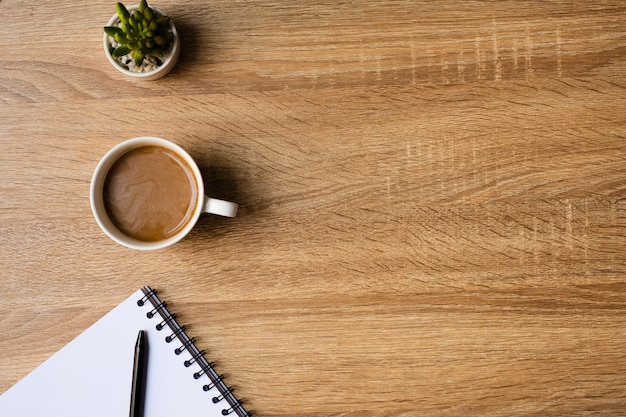 Bureau met lege Kladblok en koffiekopje op een houten tafel