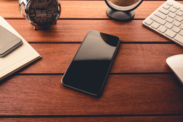 Bureau met smartphone en benodigdheden. Bovenaanzicht.