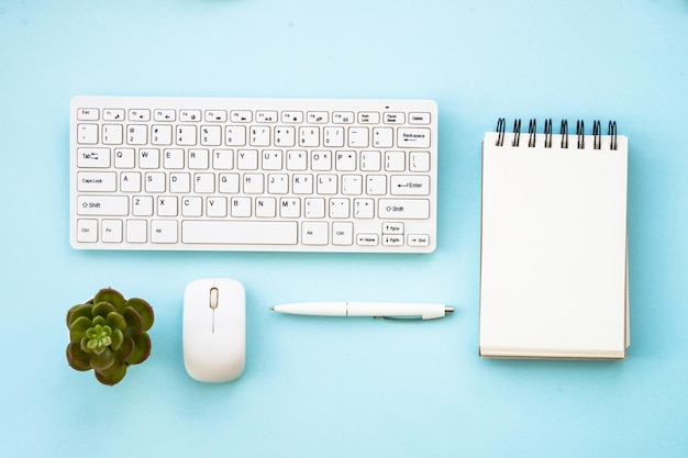 Foto bureau plat lag achtergrond met toetsenbord kladblok groene plant muis en pen