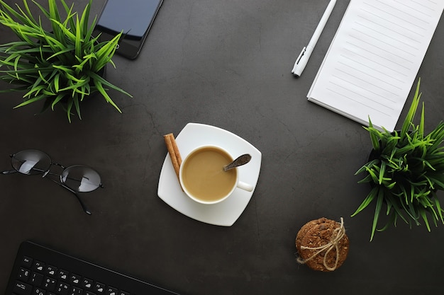 Bureaubladachtergrond met een kopje koffie en schrijfgerei. manager's bureau, pen, notitieboekje, computer.