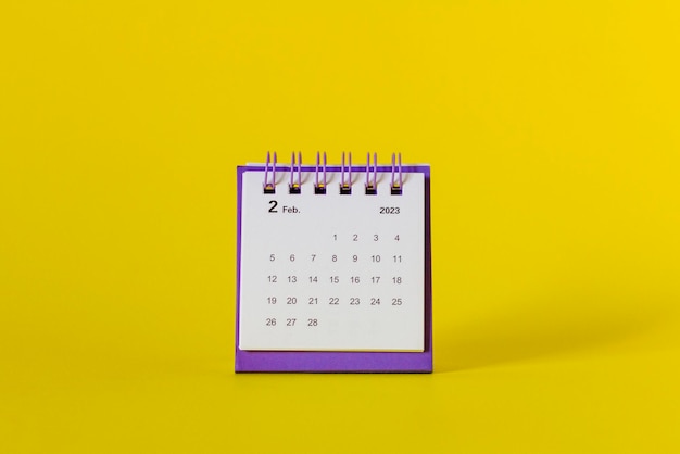 Bureaubladkalender voor februari 2023 op een gele achtergrond