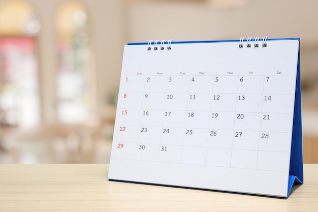 Bureaukalender op houten tafel met wazig bokeh achtergrond afspraak en zakelijke bijeenkomst concept