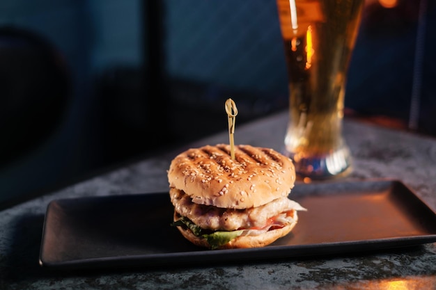 写真 ハンバーガーとビールのセット赤いバーで飲み物と軽食ファーストフード牛肉とビールのクローズアップのグラスとハンバーガー