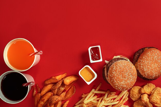 Burger and chips hamburger and french fries in red paper box fast food on red background