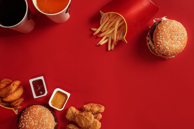 Гамбургер и чипсы, гамбургер и картофель фри в красной бумажной коробке фаст-фуд на красном фоне