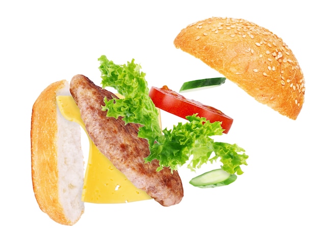 Burger components in flight on white background