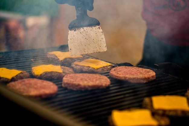 Burger cutlets are grilled. Picnic with burgers. Charcoal grill