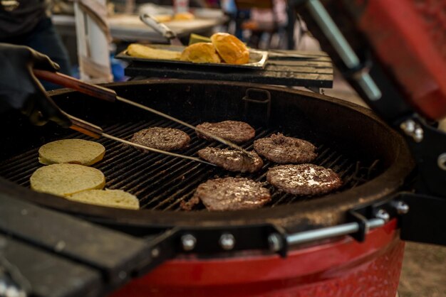 Burger cutlets are grilled. Picnic with burgers. Charcoal grill