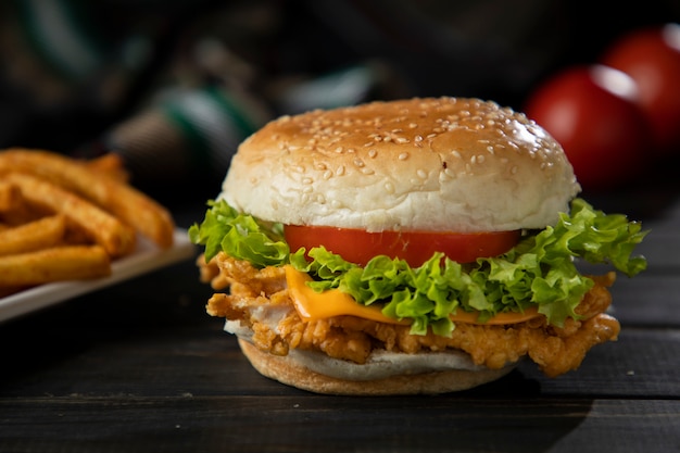 Burger in Dark Wooden Table with fries and tomato