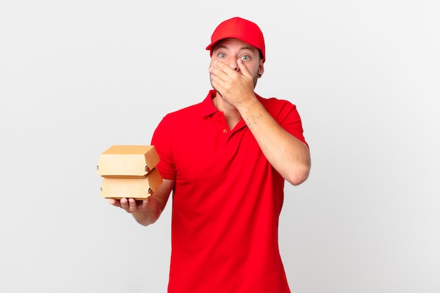 Burger deliver man covering mouth with hands with a shocked