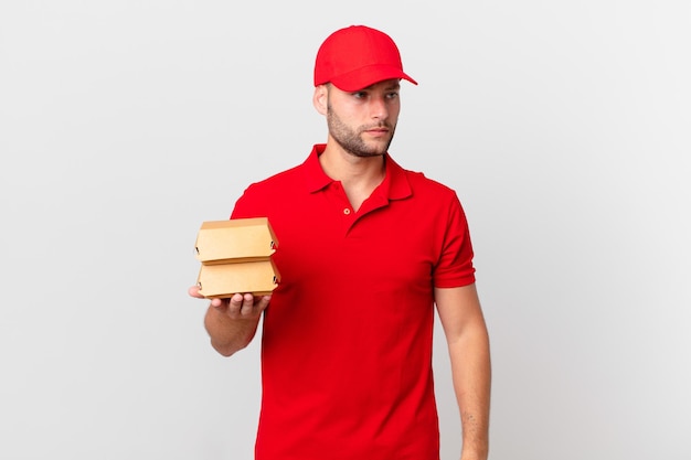 Burger deliver man feeling sad, upset or angry and looking to the side