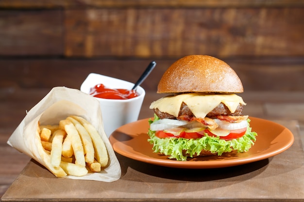 Burger and french fries on the wooden table