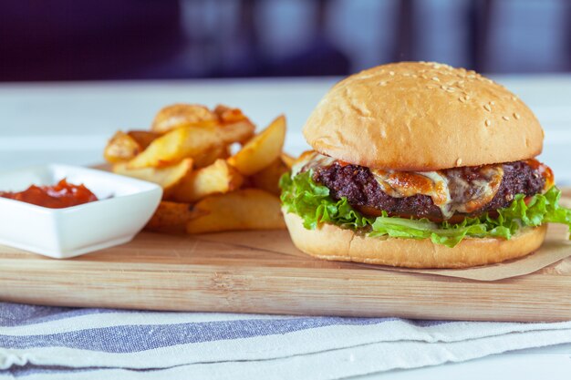 Burger and french fries on wooden table