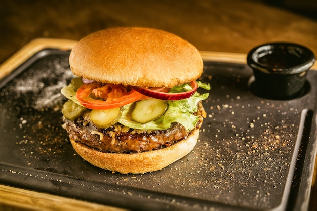 Burger full face with vegetables, spices and fries. Meat hamburger.