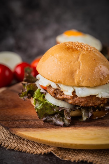 Burger geserveerd met frietjes op een houten bord