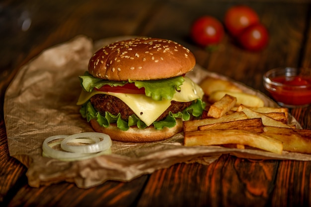 Foto hamburger o hamburger su carta pergamena su un tavolo di legno messa a fuoco selettiva