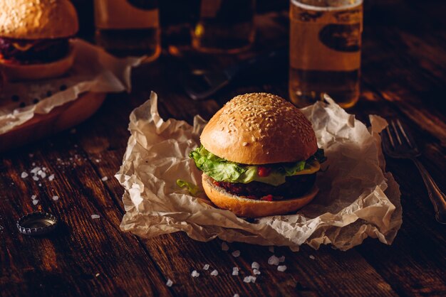 Burger on Kraft Paper. Bottles of Lager on