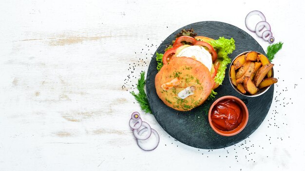 Burger met camembert kaas en vlees Frietjes en ketchup Bovenaanzicht vrije ruimte voor uw tekst Rustieke stijl