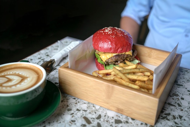 テーブルの上にコーヒーとハンバーガーとポテトチップス