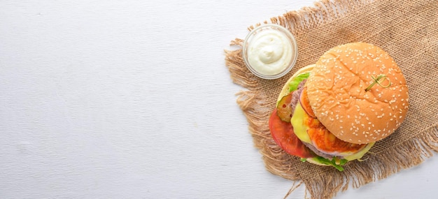 Burger and potatoes with sauce On a wooden background Top view Free space for your text