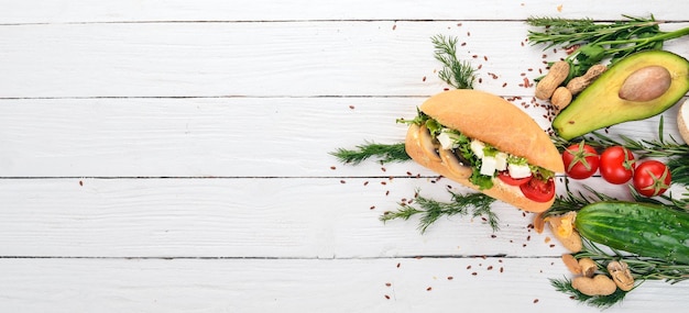 Burger sandwich with feta cheese mushrooms and lettuce leaves On a wooden background Top view Copy space