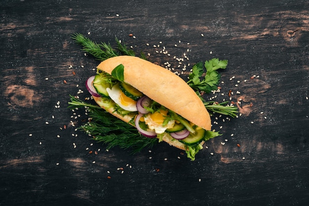 Burger sandwich with quail egg cucumber and corn On a wooden background Top view Copy space