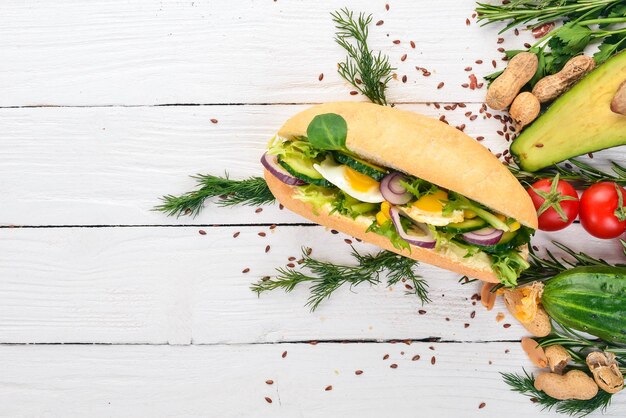 Burger sandwich with quail egg cucumber and corn On a wooden background Top view Copy space