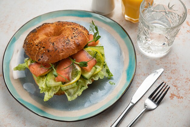 Burger sandwich with salmon, cream cheese, salad.