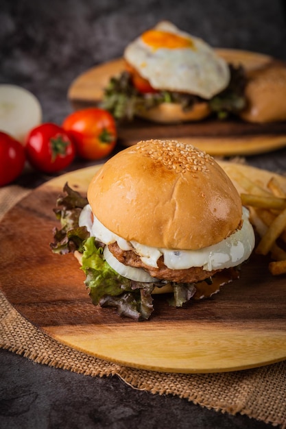 Burger served with french fries on a wooden plate