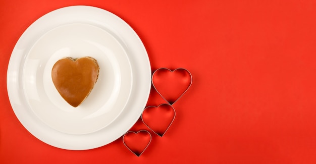 A Burger in the shape of a heart on a white plate