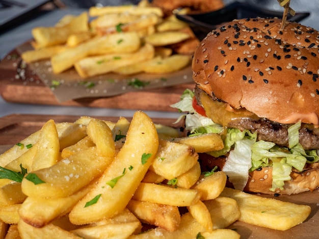 A burger sits on a table with fries