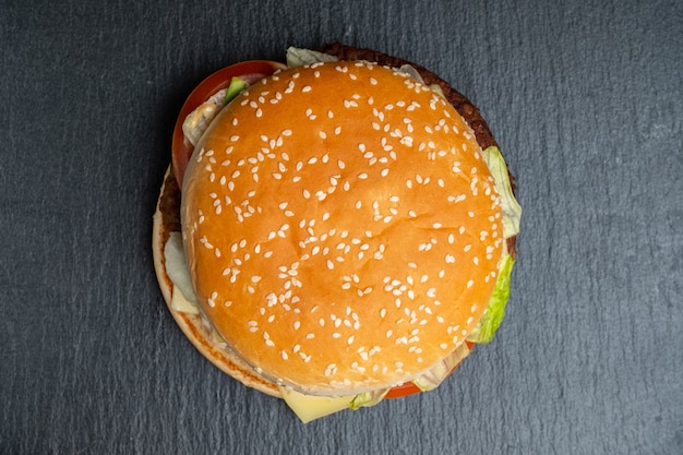 Burger on a slate, black stone tableware. Top view.