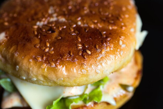 Burger with appetizing crust on a dark background