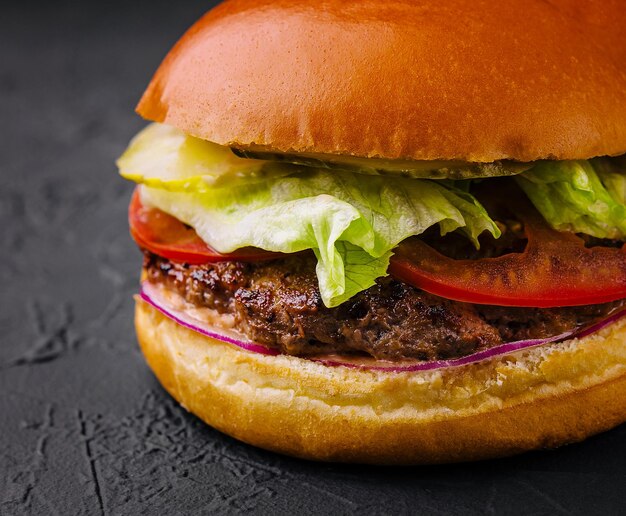 Photo burger with beef cutlet and fresh vegetables