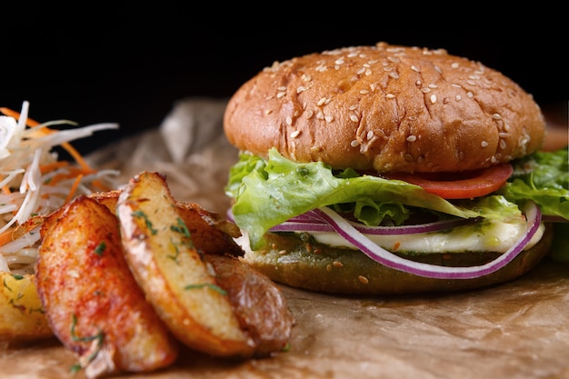 Burger with cheese, vegetables and potatoes