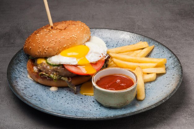 Burger with chicken cutlet and egg with french fries and ketchup