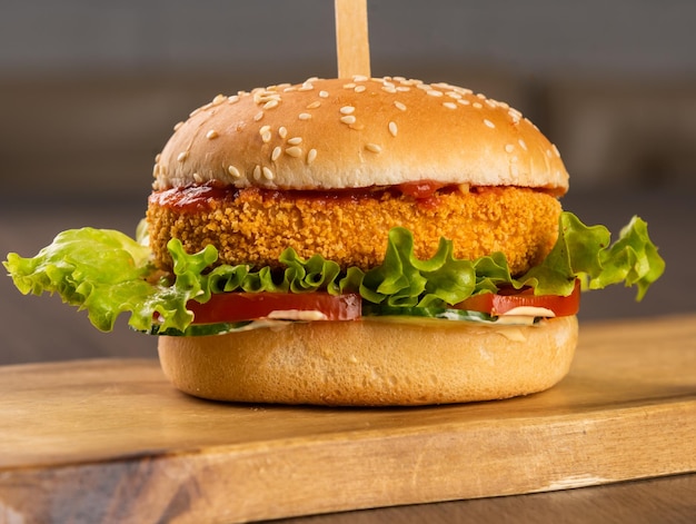 Foto burger con cotoletta di pesce con pomodori e salsa