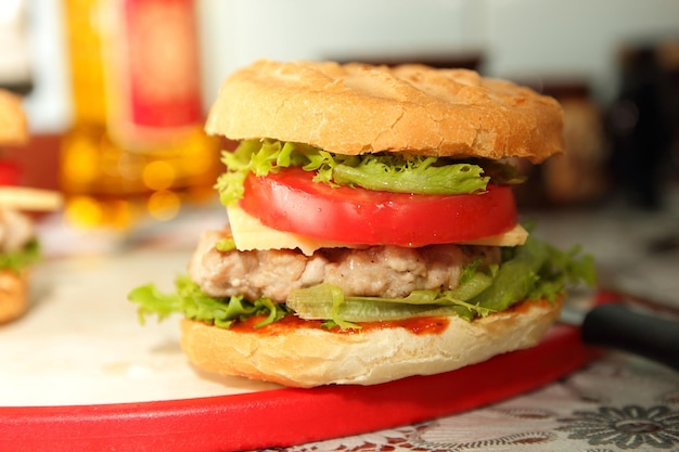 Burger with juicy cutlet cheese and fresh vegetables on the board Cooking burger in home kitchen Closeup