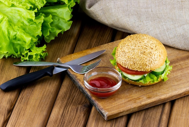 Burger with lettuce and tomato and beef on a wooden table