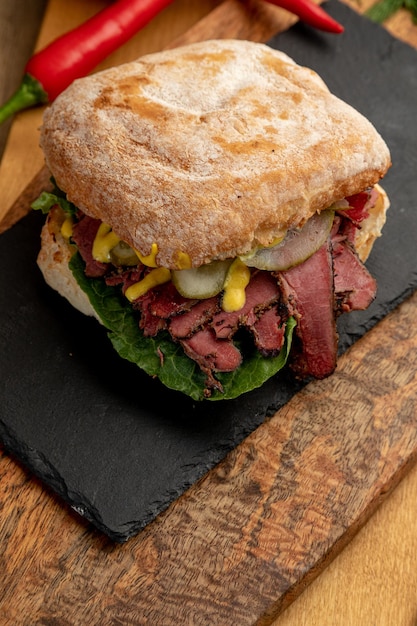 Burger with smoked beef, pickled cucumbers and fresh herbs