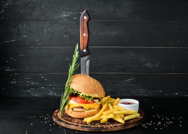 Burger with veal cheese and vegetables Fast food On a wooden background Top view Free space for your text