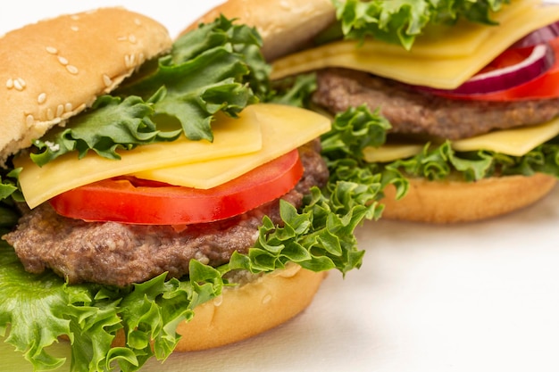 Burgerbroodje op slablad met kaas en tomaten