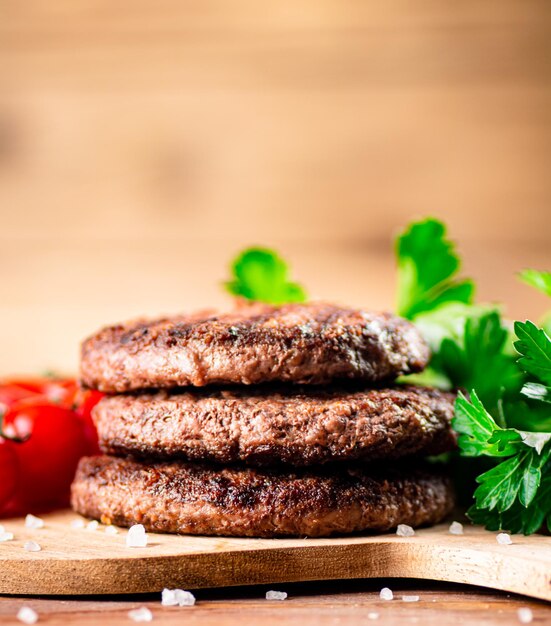 Foto burgergrill op een snijplank met groenten en tomaten